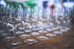 rows of wine glasses on a wooden table